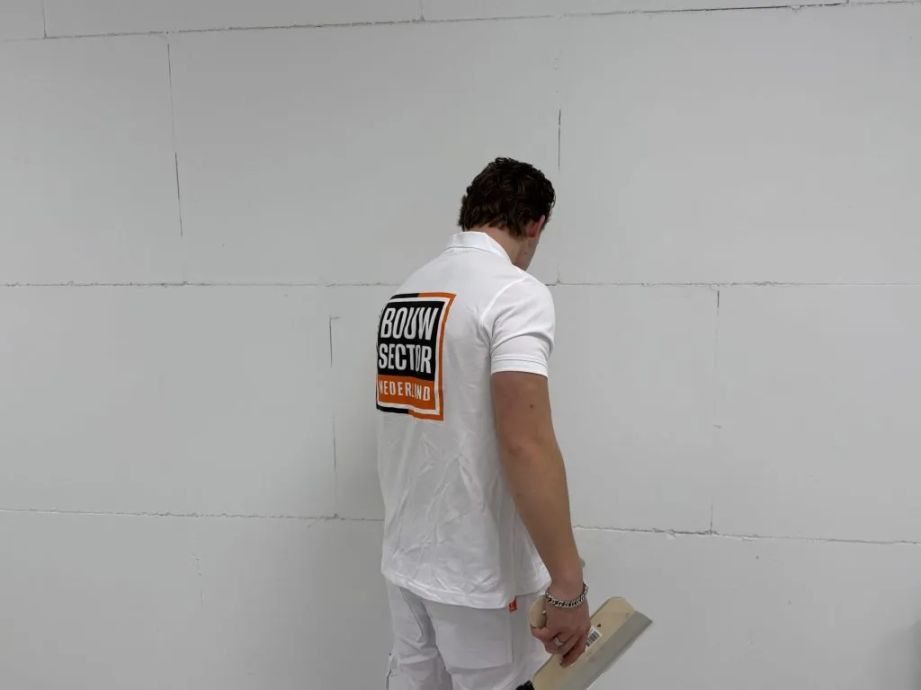 Stukadoor van Bouwsector Nederland met een plamuurmes voor een wand van gipsblokken