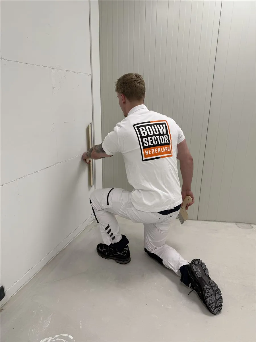 Stukadoor Bram van Bouwsector Nederland werkt een hoek af met een spaan